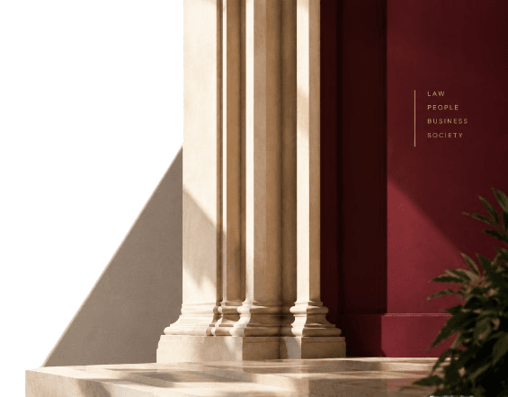 Classical stone columns against a burgundy wall, evoking permanence and structure